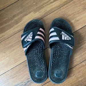 Black adidas slides with pink writing